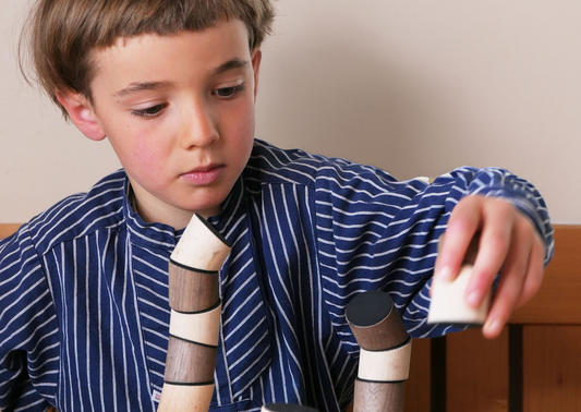 Junge beim Spielen mit dem la IDA Bauklötzen aus Holz